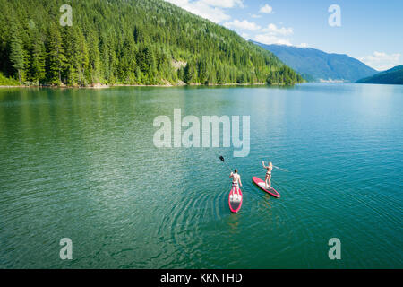 Paar Stand up paddleboarding in Fluss Stockfoto