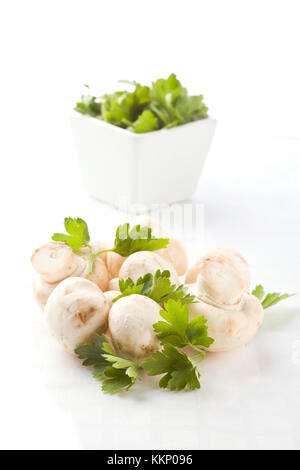 Foto von Champignons mit Petersilie auf weißen Hintergrund isoliert Stockfoto