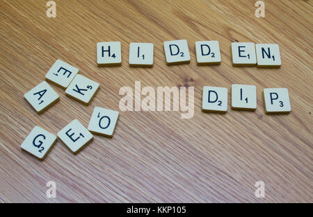 1. Dezember 2017 Elfenbein Brettspiel Buchstaben sagen Verborgenen Dip auf einer Eiche maser Hintergrund in Bangor Northern Ireland Stockfoto