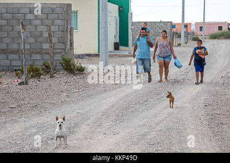 Boquillas del Carmen, Coahuila, Mexiko - Eine Familie spaziert auf einer staubigen Straße in der kleinen Grenzstadt Boquillas. Die Stadt ist beliebt bei Touristen, die Stockfoto