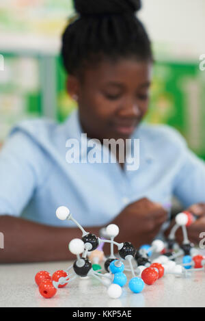 Weibliche Schüler durch die molekularen Bausatz in Wissenschaft Lektion Stockfoto