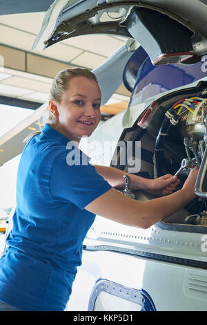 Portrait von weiblichen aero Engineer, der an Helikopter im Hangar Stockfoto