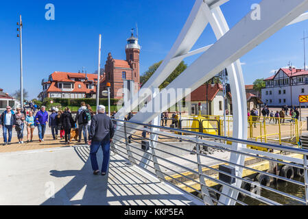 Leuchtturm von der beweglichen Fußgängerbrücke über den Hafenkanal der Slupia-Flussmündung in Ustka gesehen - kleine Ostseestadt, Pommersche Woiwodschaft Po Stockfoto