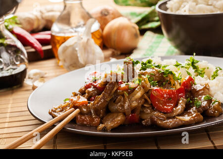 Chinesische klebrige Schweinefleisch Rinderfilet gebraten mit einem süßen und herzhaften Soße mit gekochtem Reis serviert Stockfoto