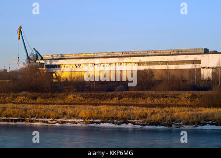 Überdachte Dock der Schiffsreparatur Yard für Fluss Schiffe auf dem Überwachsen mit trockenem Gras und Büschen Bank auf die Gracht, die in der untergehenden Sonne Stockfoto