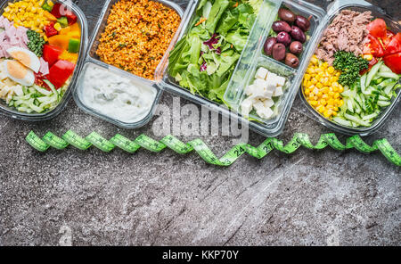 Diät Nahrung und Lunchboxen Konzept. verschiedene gesunde Gemüse Salate im Kunststoffgehäuse mit Messung Klebeband, Ansicht von oben, Grenze. Diät. Stockfoto