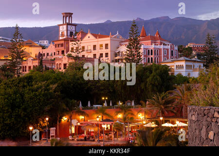 Restaurants und Einrichtungen des Hotels an der Promenade von Playa del Duque im Abendlicht, Costa Adeje, Teneriffa, Kanarische Inseln, Spanien Stockfoto