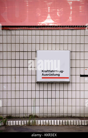 Eine Garage im Vintage-Stil mit weißen Ziegeln und verblassten Schildern. Stockfoto