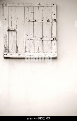 Ein markantes Dachfenster aus Holz mit abblätternder Farbe. Stockfoto