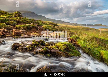 Brautschleier Wasserfall mit Old man of Storr im Hintergrund. Isle of Skye, Schottland. Stockfoto