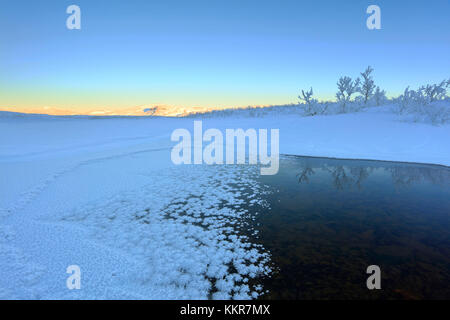 Sonnenaufgang auf dem gefrorenen Fluss, abisko, Norrbotten County, Gemeinde Kiruna, Lappland, Schweden Stockfoto