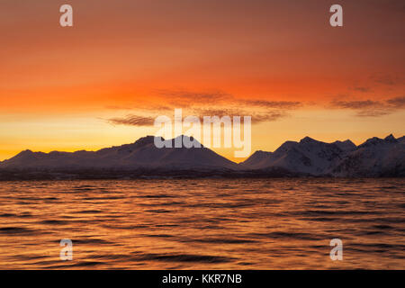 Die Farben des Sonnenuntergangs im Fjord wider. Nordmannvik, Kafjord, Lyngen Alpen, Troms, Norwegen, Lappland, Europa. Stockfoto