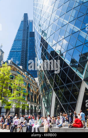 England, London, London, Büroarbeiter entspannend auf der Basis von 30 St Mary Axe aka The Gherkin Stockfoto