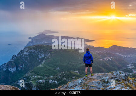 San Michele Berg, Pimonte, Napoli, Kampanien, Italien. Sonnenuntergang über der Halbinsel von Sorrent und Capri. Ein Wanderer bewundert die Ansicht Stockfoto