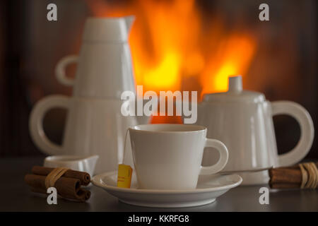 Eine Tasse Tee am Kamin, weißes Porzellan Geschirr Stockfoto