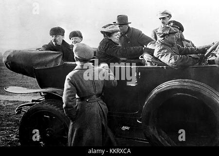 Dieses Foto von 1918 zeigt Lenin, Nadezhda Krupskaja und Maria Uljanova in einem Auto bei einer Parade der Roten Armee. Es ist ein bedeutendes historisches Bild, das sowjetische Führer in den Anfängen der bolschewistischen Regierung darstellt. Stockfoto