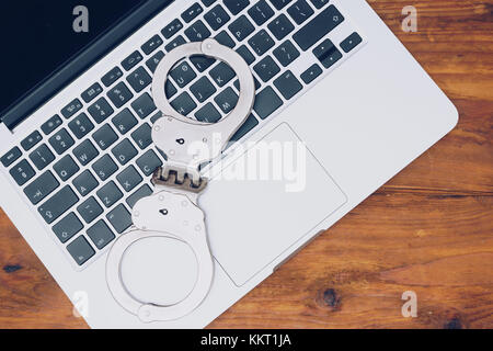 Handschellen auf latop Tastatur, Konzept der Internetkriminalität, Hacking und cyber Verbrechen Stockfoto