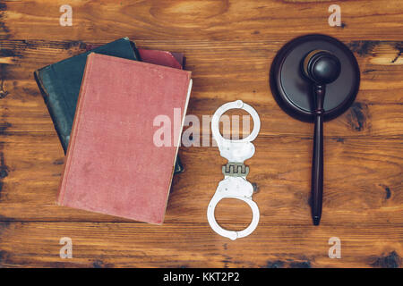 Richter Hammer, recht Bücher und Handschellen auf einem hölzernen Hintergrund Stockfoto