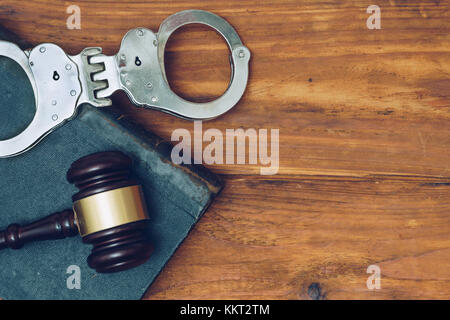 Richter Hammer, recht Bücher und Handschellen auf einem hölzernen Hintergrund Stockfoto