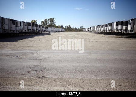 Reihen von gekühlten Fracht Anhänger in viel an einem Depot geparkten für die Verteilung der kalte Produkte und produzieren in einem rückläufigen Low Angle View Stockfoto