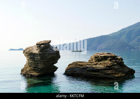 Ein Boot zwischen zwei Felsen im Golden Beach in Thassos gesehen Stockfoto