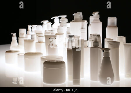 Gruppe von Leer kosmetische Flaschen in Silhouette, weil der Rücken niedriger Beleuchtung Stockfoto