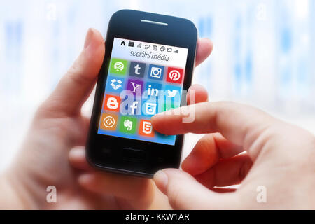 Soziale Medien, moderne mobile Kommunikation - in einer Hand Smartphone - Facebook, Twitter, google, Linkedin, Youtube, Pöcking, Symbole Stockfoto