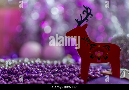 Weihnachtsschmuck eines roten regen Rehe in geringer Tiefenschärfe. cremig violetten Hintergrund. Stockfoto