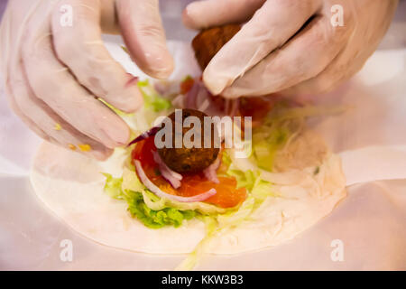 Hände tacos Vorbereitung und felafel an Street Fair Stockfoto