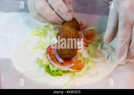 Hände tacos Vorbereitung und felafel an Street Fair Stockfoto