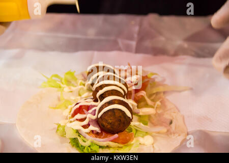 Hände tacos Vorbereitung und felafel an Street Fair Stockfoto