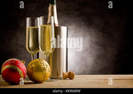 Champagner Gläser auf Holztisch mit Weihnachtsverzierungen Stockfoto