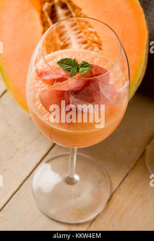 Foto von köstlichen Schinken und Melone cocktail Aperitif auf Holztisch Stockfoto