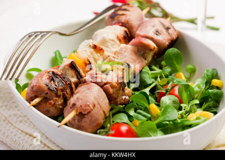 köstliche gegrillte Fleischspieße auf weißen Tisch Stockfoto