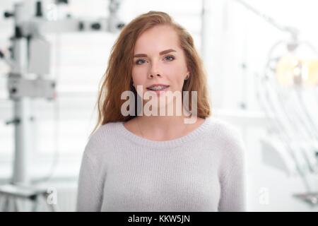 Junge Frau, die in der Zahnarztpraxis Stockfoto