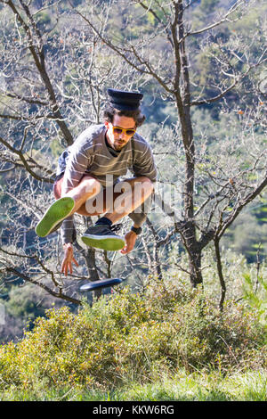 Ein Junge springt in die Luft, um die Frisbee on the fly zu ergreifen. Stockfoto