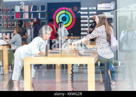 Portland, Oregon, USA - September 9th, 2017: Blick von zwei weiblichen Kunden durch die Schaufenster von einem überfüllten Apple Store in der Innenstadt entfernt Stockfoto