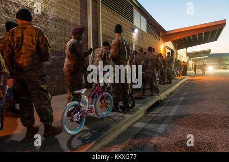 Fort Bragg, NC, USA. Dezember 2017. 1. Dezember 2017 - FORT BRAGG, N.C., USA - Fallschirmjäger säumen die Straße an der Green Ramp auf dem Pope Army Airfield am Freitag, wenn die Sonne aufgeht und warten darauf, ihr Spielzeug beim 20. Jährlichen Randy Oller Memorial Operation Toy Drop zu spenden. Die Luftlandeoperation, die vom U.S. Army Civil Affairs & Psychological Operations Command (Airborne) geleitet wird, ist die weltweit größte kombinierte Luftlandeoperation, an der Fallschirmjäger aus neun alliierten Nationen teilnehmen. Die jährliche Veranstaltung bietet Fallschirmjägern die Möglichkeit, Kindern in Gemeinden rund um Fort Bragg Race zu helfen Stockfoto