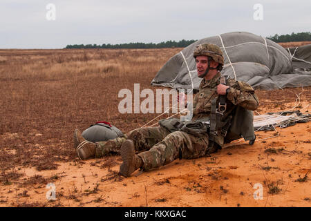 Fort Bragg, NC, USA. Dezember 2017. 2. Dezember 2017: FORT BRAGG, N.C., USA - SPC. Ryan Mitchell, Fallschirmjäger der US-Armee mit dem 307. Ingenieur-Bataillon, 3. Brigade Combat Team, 82. Luftlandedivision, hebt seinen Fallschirm in der Drop Zone von Sizilien für die 20. Jährliche Randy Oller Memorial Operation Toy Drop auf, die vom U.S. Army Civil Affairs & Psychological Operations Command (Airborne) veranstaltet wird. Die jährliche Veranstaltung, die als die weltweit größte kombinierte Luftlandeoperation mit Fallschirmjägern aus neun alliierten Nationen gilt, bietet Fallschirmjägern die Möglichkeit, Kindern in den umliegenden Gemeinden zu helfen Stockfoto