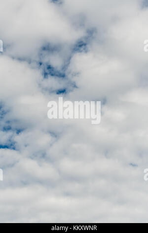 Geschwollene weiße Wolken über dem strahlend blauen Himmel vertikale Hintergrundbild Stockfoto
