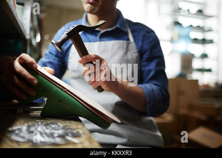 Schuhe Handwerker hämmern Nägel in Schuhsohle während der Arbeit Stockfoto