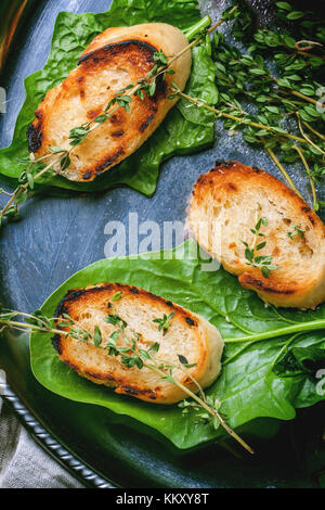 Fried Bread Croutons mit Thymian und Spinatblätter auf Silber fach Ansicht von oben Stockfoto