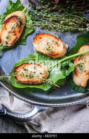 Fried Bread Croutons mit Thymian und Spinatblätter auf Silber fach Ansicht von oben Stockfoto