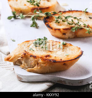 Fried Bread Croutons mit Thymian und Spinatblätter auf Weiß Schneidebrett. square Bild mit selektiven Fokus Stockfoto