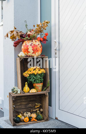 Eingang, Holzkisten, herbstliche Dekoration, Kürbisse, Blumen Stockfotografie