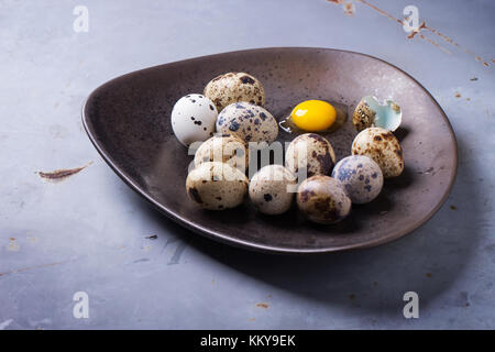 Wachteleier in braun Keramik Platte über graue Oberfläche aus Metall. Stockfoto