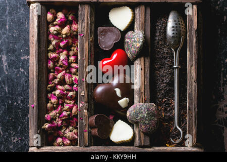 Valentinstag Grusskarten mit trockenen Tee, Herz von Kaffee und Schokolade. Ansicht von oben. Stockfoto