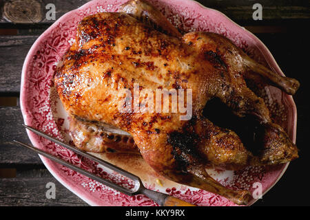 Ganze gebratene Entenbrust mit Honig Fleisch Gabel in vintage Platte, diente über alten Holztisch. top View Stockfoto