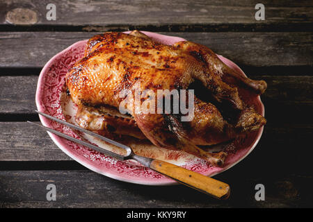 Ganze gebratene Entenbrust mit Honig Fleisch Gabel in vintage Platte, diente über alten Holztisch. Stockfoto