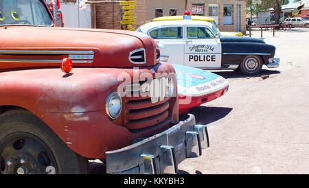 Seligman, Arizona, USA, Juni 23,2013: 1948 Ford Abschleppwagen und vintage Polizei Auto an Seligman Verbrauchsmaterialien Geschenk Shop auf der Route 66. Stockfoto